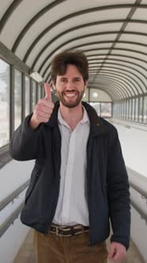 Young Man Gives Double Thumbs Up in Urban Setting