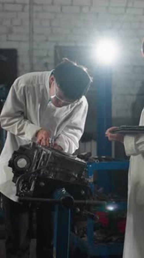 Engineers Measuring Engine Component with Vernier Caliper in Automotive Workshop