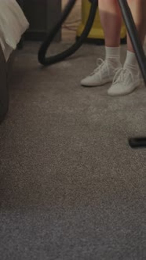Housekeeper Using Modern Vacuum Cleaner in Luxury Hotel Suite