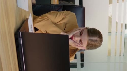 Frustrated Woman Rubbing Temples at Work