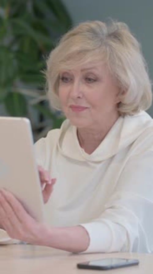 Cheerful Old Woman using Tablet PC, vertical video