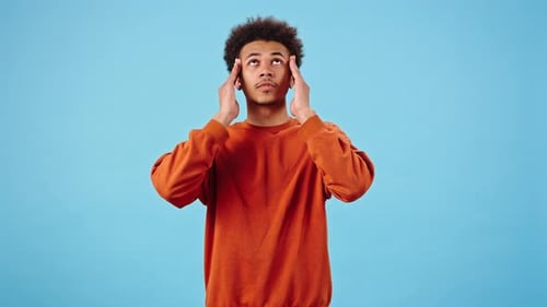 Young Man Rubbing Temples From Headache Pain