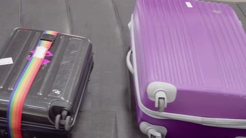 Top view of suitcases on moving luggage conveyor belt
