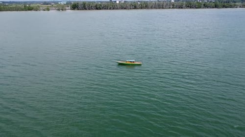 View of fishing boats sailing on the sea with mountains and clouds in the background