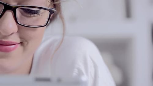 Young Woman Smiling, Looking at Tablet, Indoors