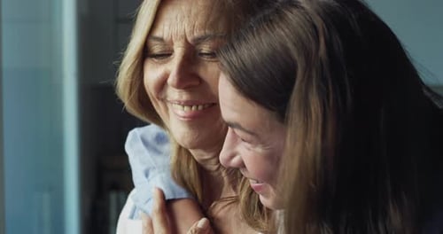 Loving Daughter Hugging Her Mother at Home