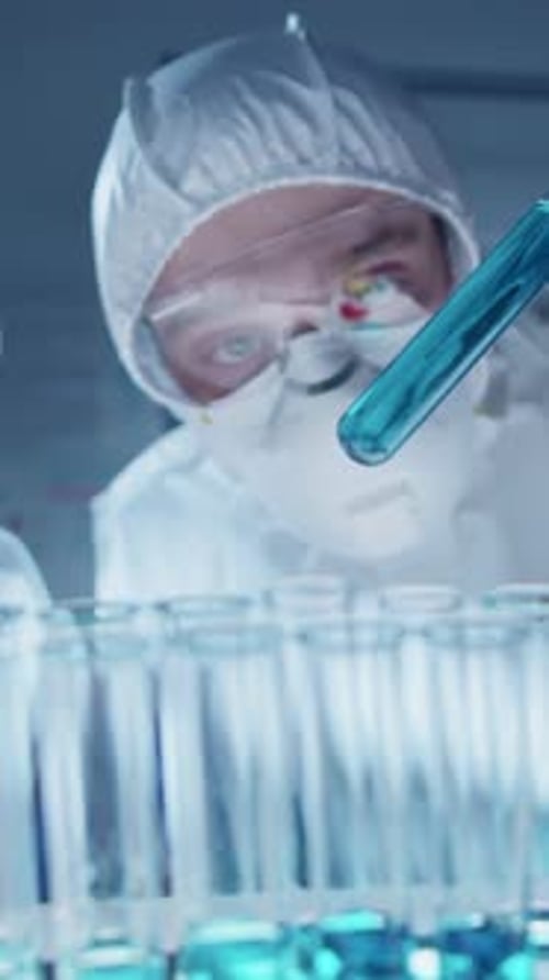 Medical Worker Examines Blue Liquid in Test Tubes