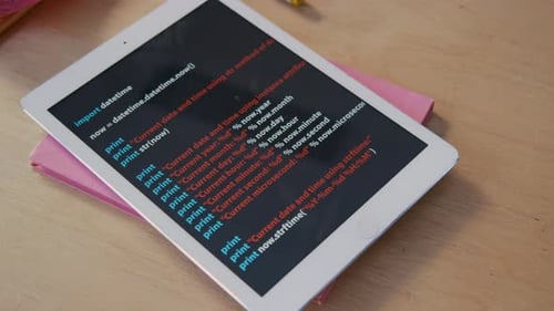 Digital Tablet with Programming Code on Desk in Classroom