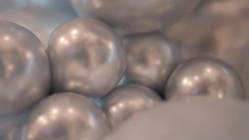 Abstrakte Nahaufnahme silberner metallischer Ballonkugeln, die den Innenraum reflektieren.
