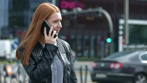 Young woman getting bad news through the cellphone. Busy city in the background.