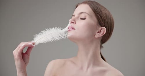 Elegant Woman Posing with a White Feather