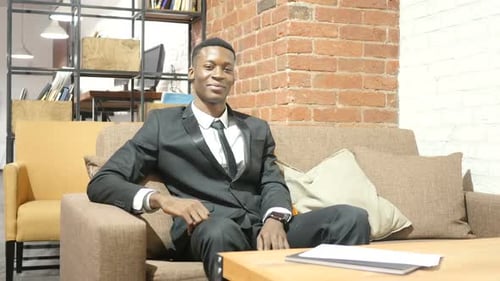 Professional Man Sitting on Sofa in Office