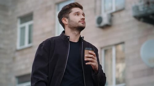Stylish Man Drinks Coffee Outdoors in Urban Setting