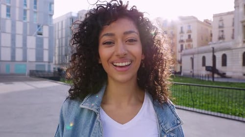 Smiling Woman with Curly Hair in City