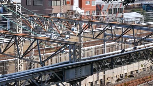 POV zoom into train railway while train is passing in daytime. Transportation in big city.