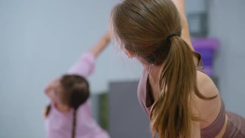 Gym Instructor Leads Kids in Arm Stretch Exercise Session
