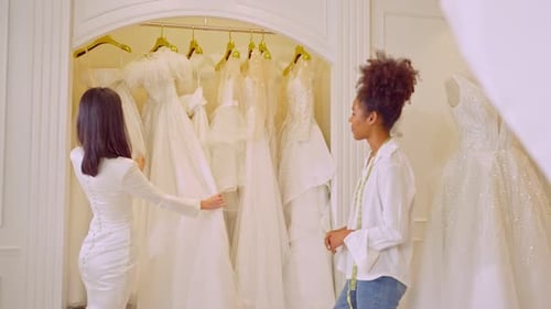 Beautiful bride discussing details with the wedding planner in studio.