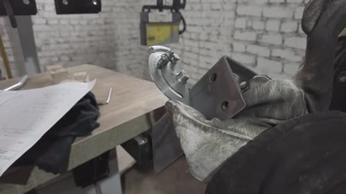 Metalworker Measuring Angle with Protractor at Workbench