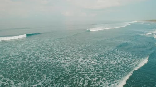 Endless turquoise ocean with soft waves forming patterns under clear sky