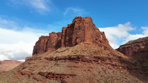 Drohnenschwenkung rund um Red Butte in der Wüste mit Wolken und blauem Himmel im Hintergrund. Moab, Utah, Earl