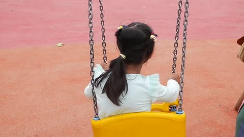 un enfant s'amuse sur une balançoire sur le terrain de jeu dans un parc public