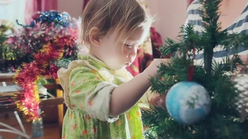 Child Decorates Christmas Tree with Family