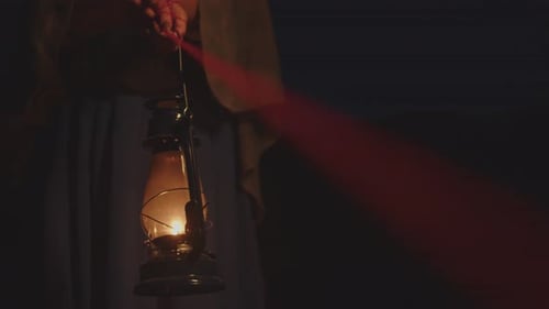 Person Holds Lantern at Night in Darkness