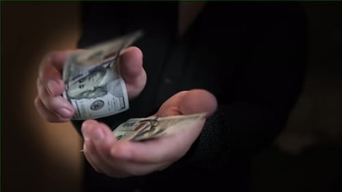 Close-up man took two dollar bills and plays with them as if it were the mouth of an animal