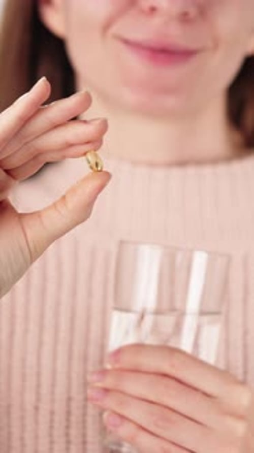 Woman Holding Vitamin D Softgel With Water Daily Immunity Supplement