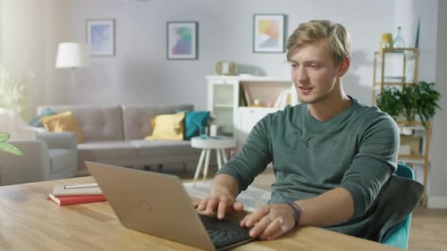 Man working on laptop computer at home, daytime