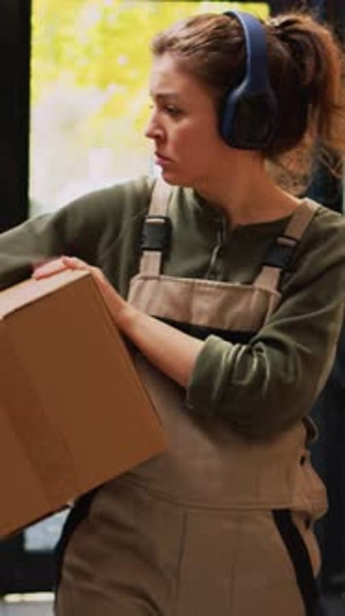 Vertical Video Employee Moving Stock Boxes on Racks