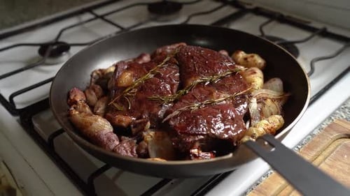 Delicious Steak Cooking on Stovetop with Onions