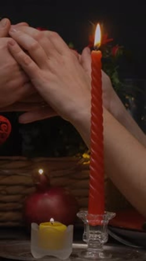 Loving Couple Holding Hands in Romantic Candlelight