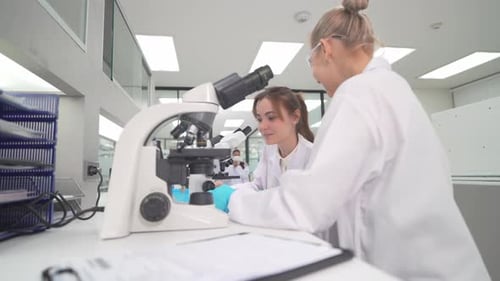 Scientists Doing Research with Microscope in Lab