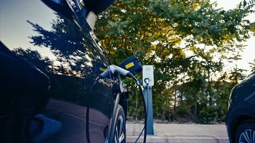 Electric car plugged and charging at a charging station. 8k