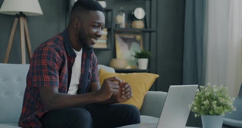 Man Video Conferencing on Laptop at Home
