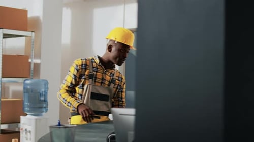 Afroamerikanische Arbeiter schauen sich Kisten mit Produkten an