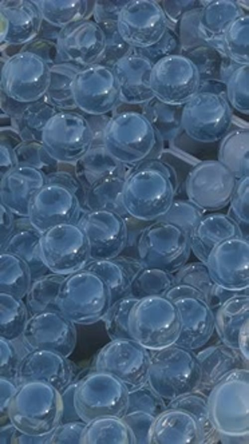 Animated Clear Spheres Pouring into Geometric Grid Cells