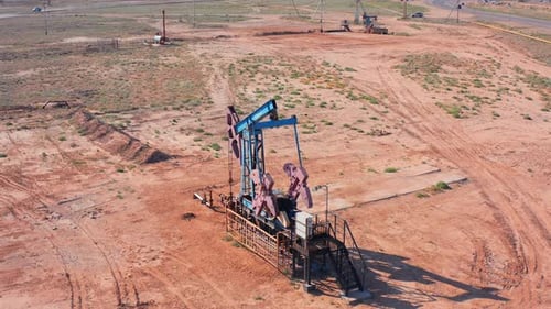 Oil Pumpjack in Desert Field Extracting Crude Petroleum