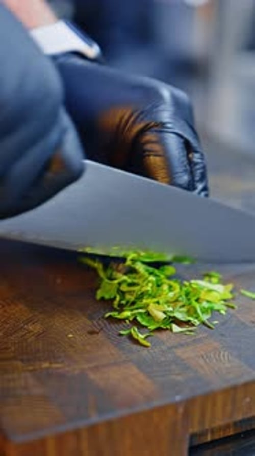 Parsley is cut on the wooden board. Healthy food preparation. Close up. Vertical video.