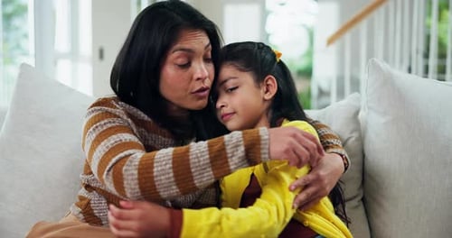 Caring Woman Comforts Young Girl at Home