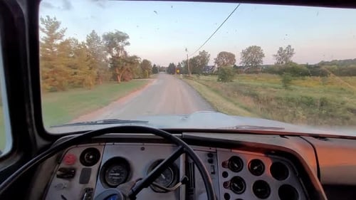 POV driving old dump truck down bumpy dirt road in rural America