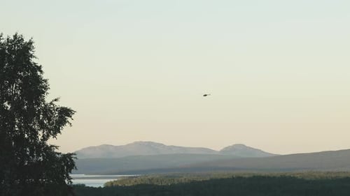 helicopter flying over the mountainous area of Klimpfjall, north of Sweden, at dusk. slowmotion
