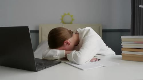 Tired Student Sleeping on Desk After Studying