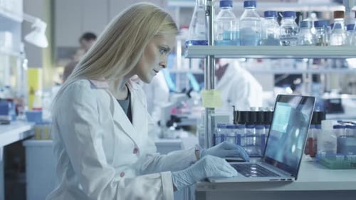 Female Scientist Typing on Laptop in Laboratory