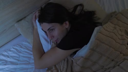 Woman Lying Awake in Bed at Night