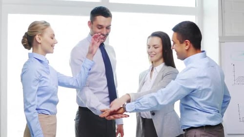 Smiling business team united hands show startup success in modern office