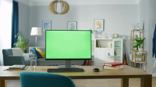Modern Personal Computer with Mock-up Green Screen Display Standing on the Desk of the Cozy Home Of