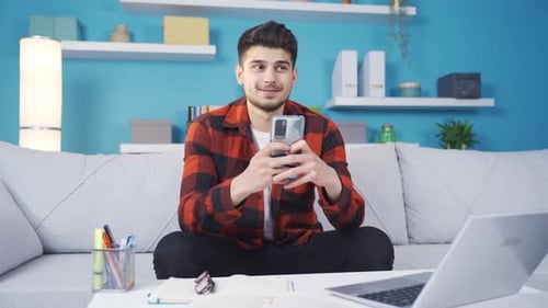 Man Using Phone and Sitting on Couch