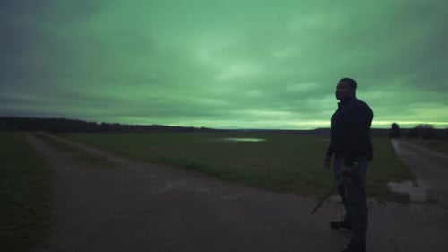 Modern Black Swordsman Warrior Awaiting Battle Opponent in Open Field Under Green Sky, Europe, 4K Mu